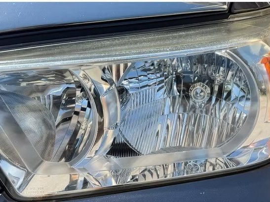 The same Toyota Tacoma headlight after restoration, clear enough to see the reflector